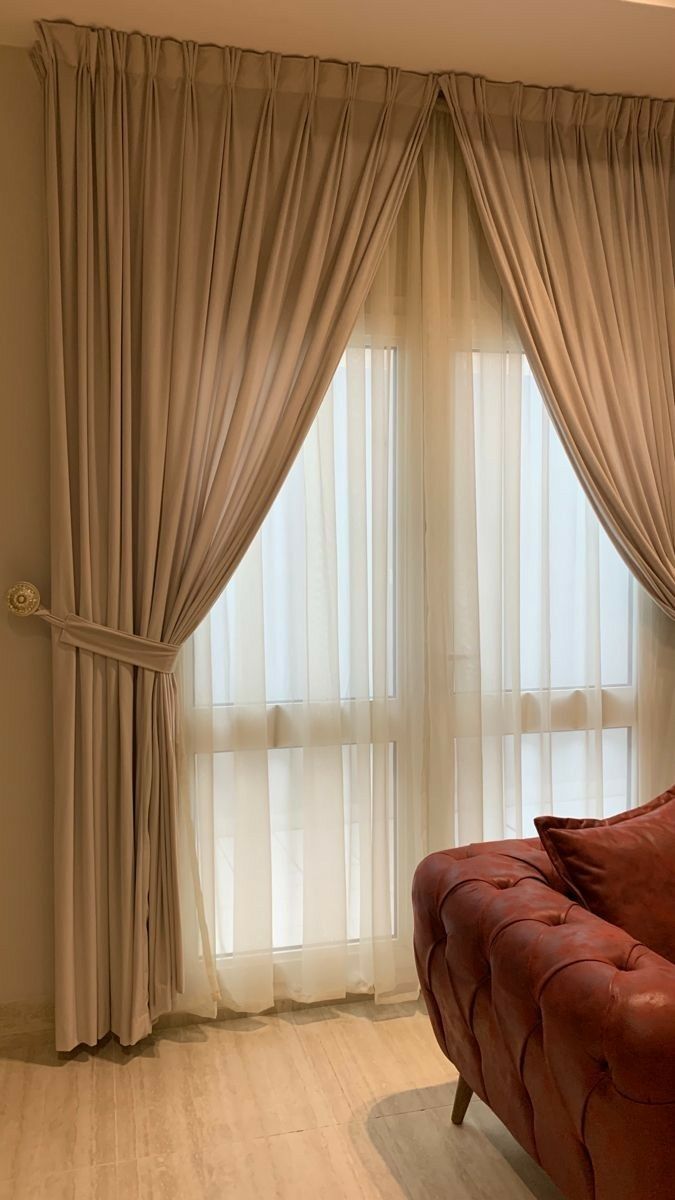 Elegant beige curtains with sheer white voile and terracotta armchair